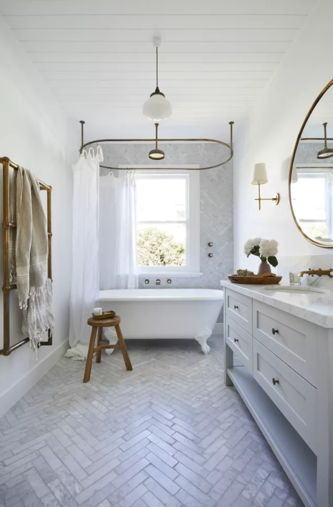 baignoire autoportante avec carrelage en marbre à chevrons dans une salle de bains
