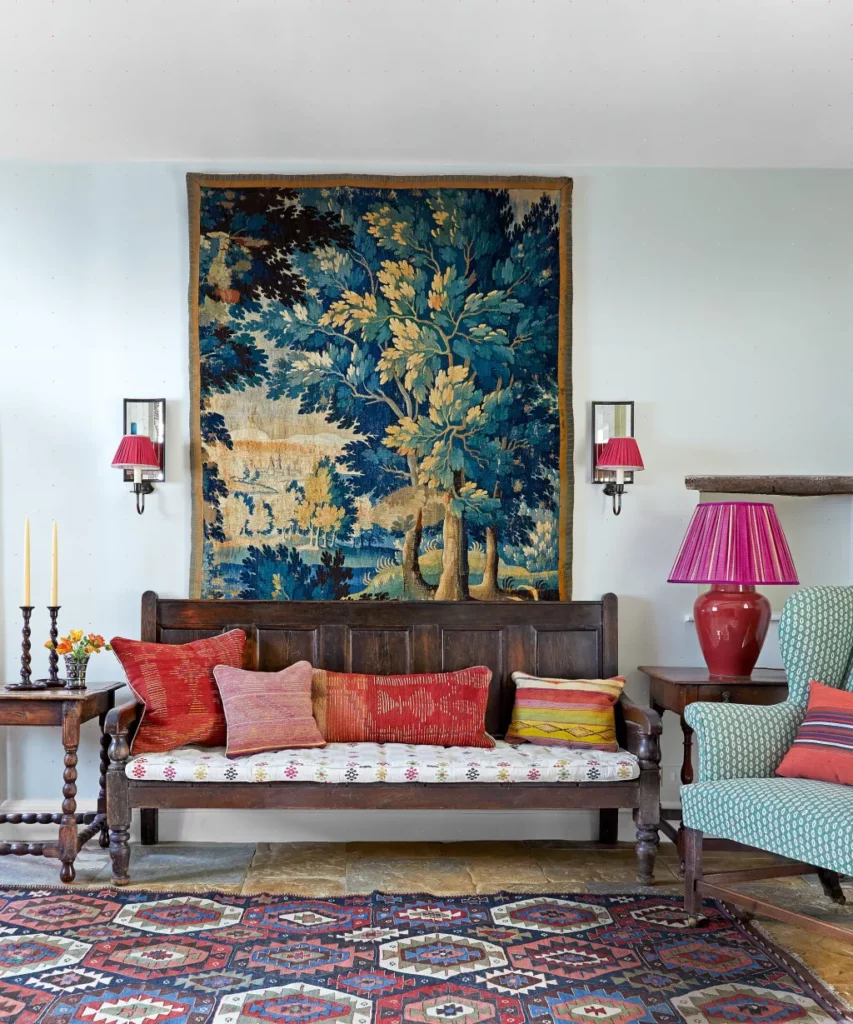 Hall coloré avec tapisserie Verdure, kilim ancien et banc en bois.
