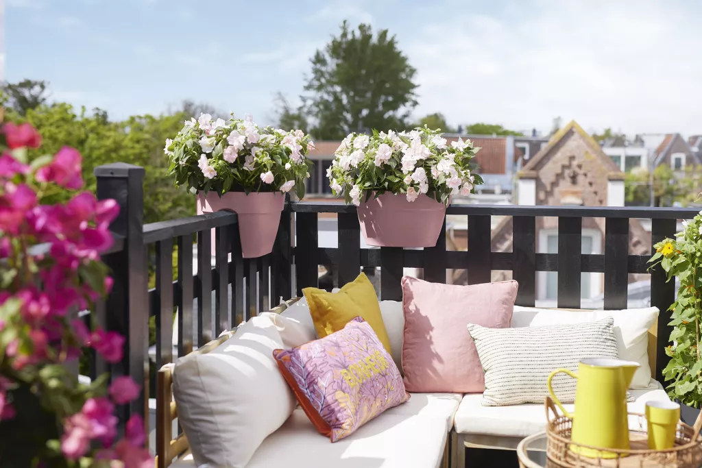 Balcon avec canapé d'angle et balustrade avec jardinières