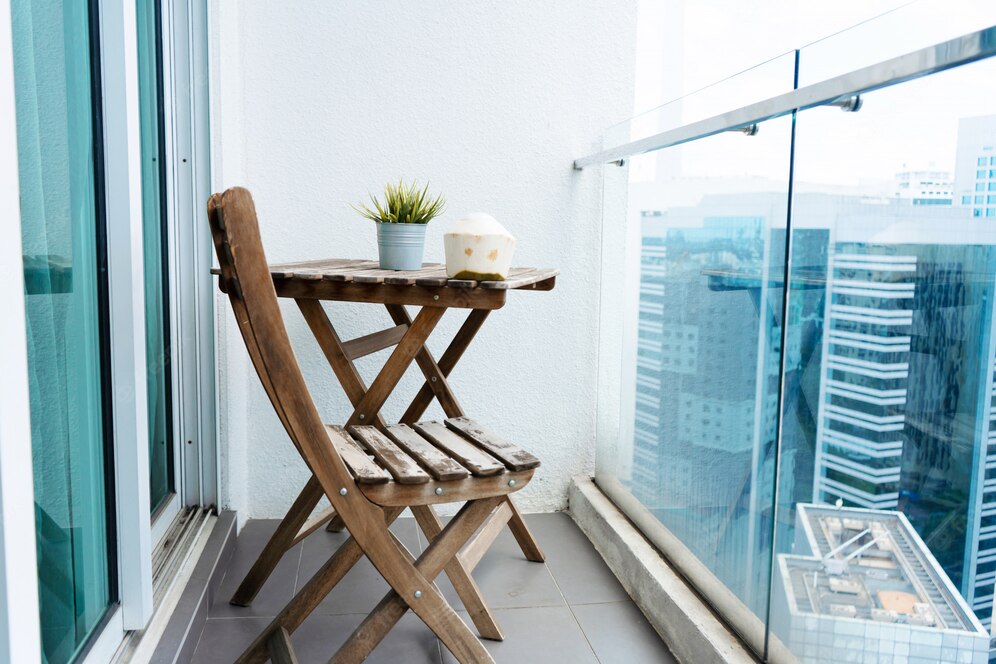 Table et chaise en bois sur le balcon donnant sur la grande ville moderne