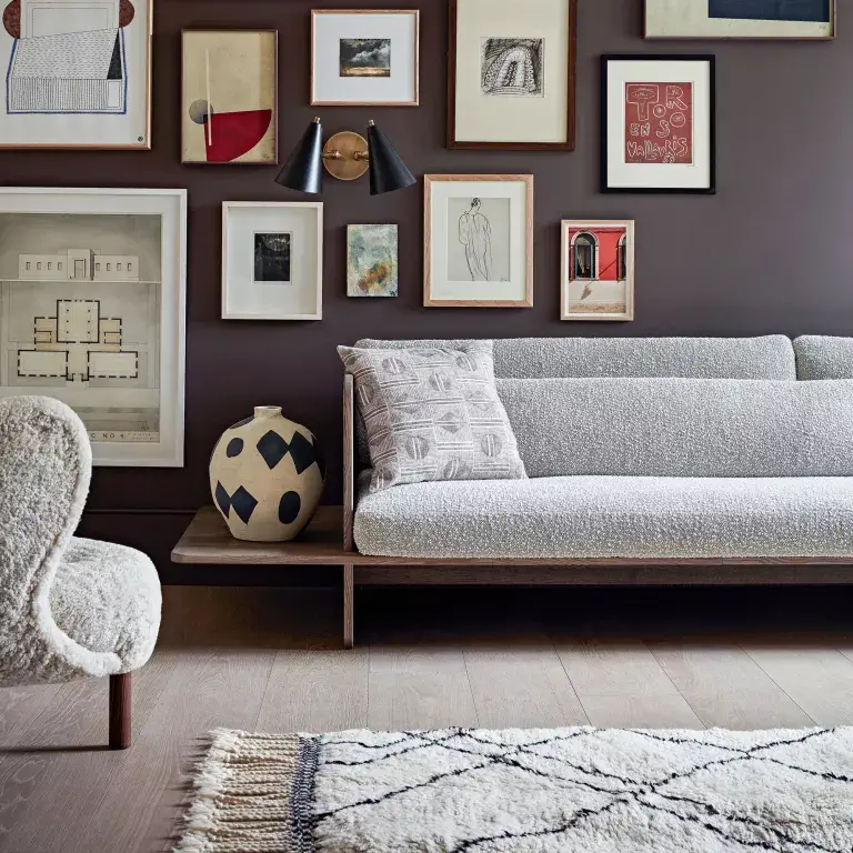 espace de vie élégant avec canapé en boucle, tapis doux et mur d'exposition