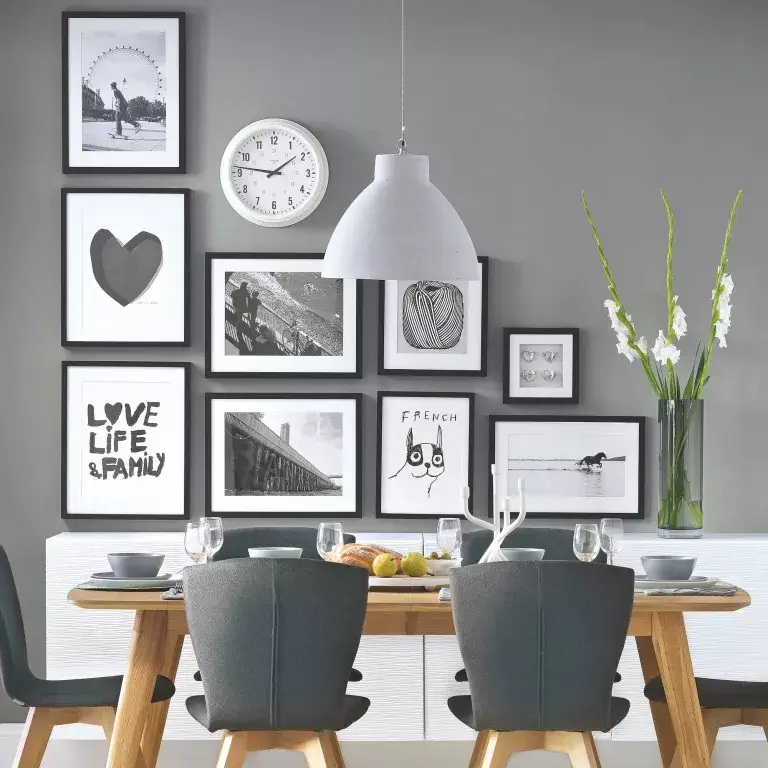 Salle à manger grise avec mur galerie noir et blanc
