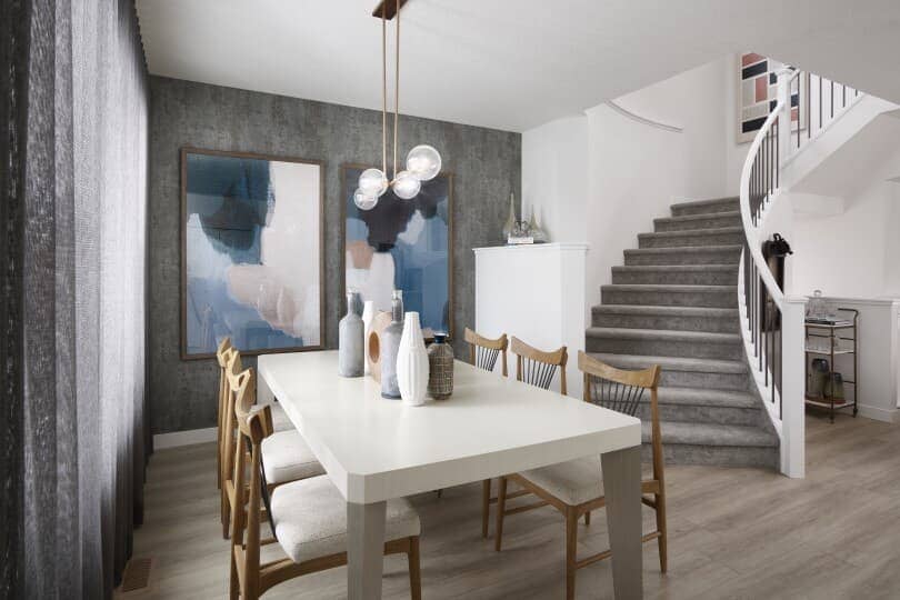 Salle à manger avec papier peint et escalier courbe dans une maison 