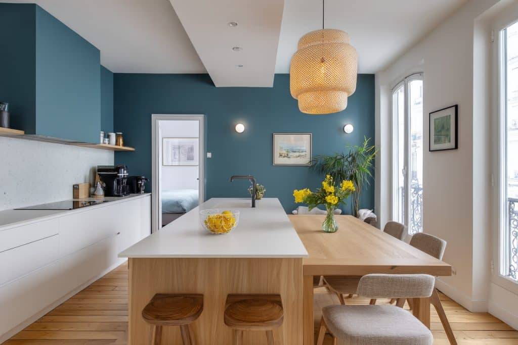 cuisine blanche bleu canard et bois, mur et haut de cuisine bleu canard meuble blanc et salle à manger couleur bois tendance chic