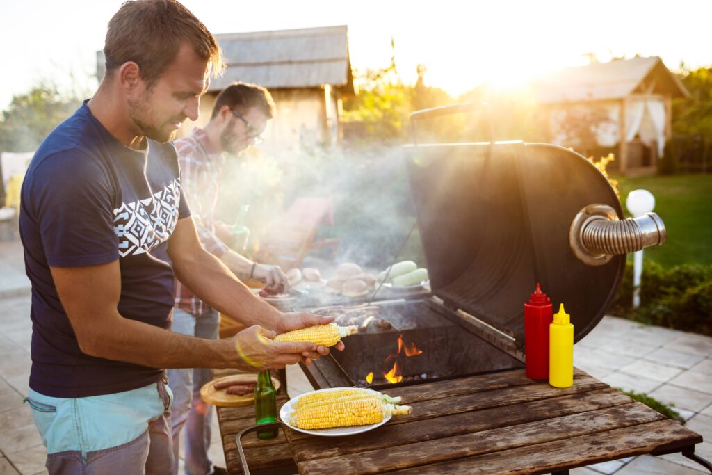 deux hommes en train de faire un barbecue aménagement barbecue extérieur convivial
