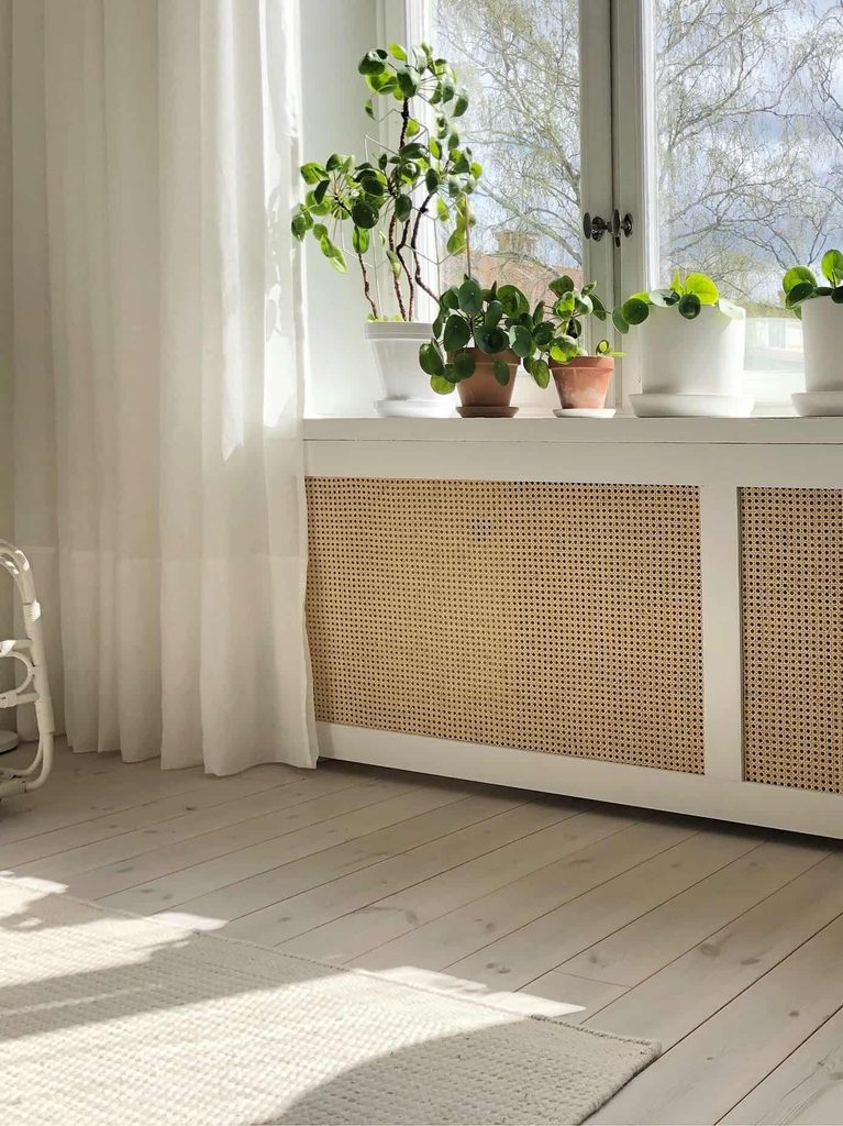 Le panneau amovible peint dans la couleur du mur pour cacher un radiateur électrique à l'entrée sous fenêtre